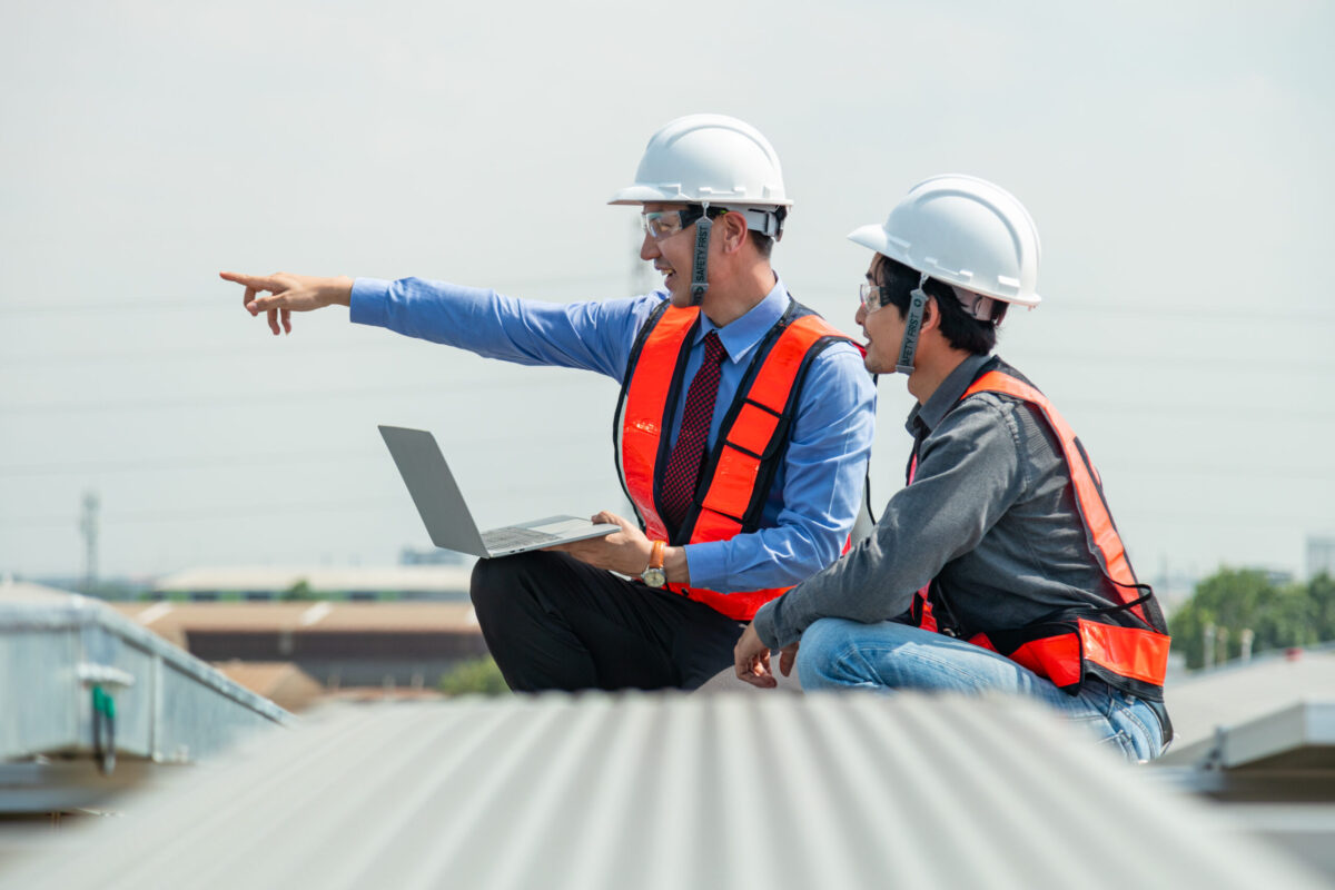 Engineers and technicians check drawings for installing solar cell panels on the roof. alternative energy energy from the sun